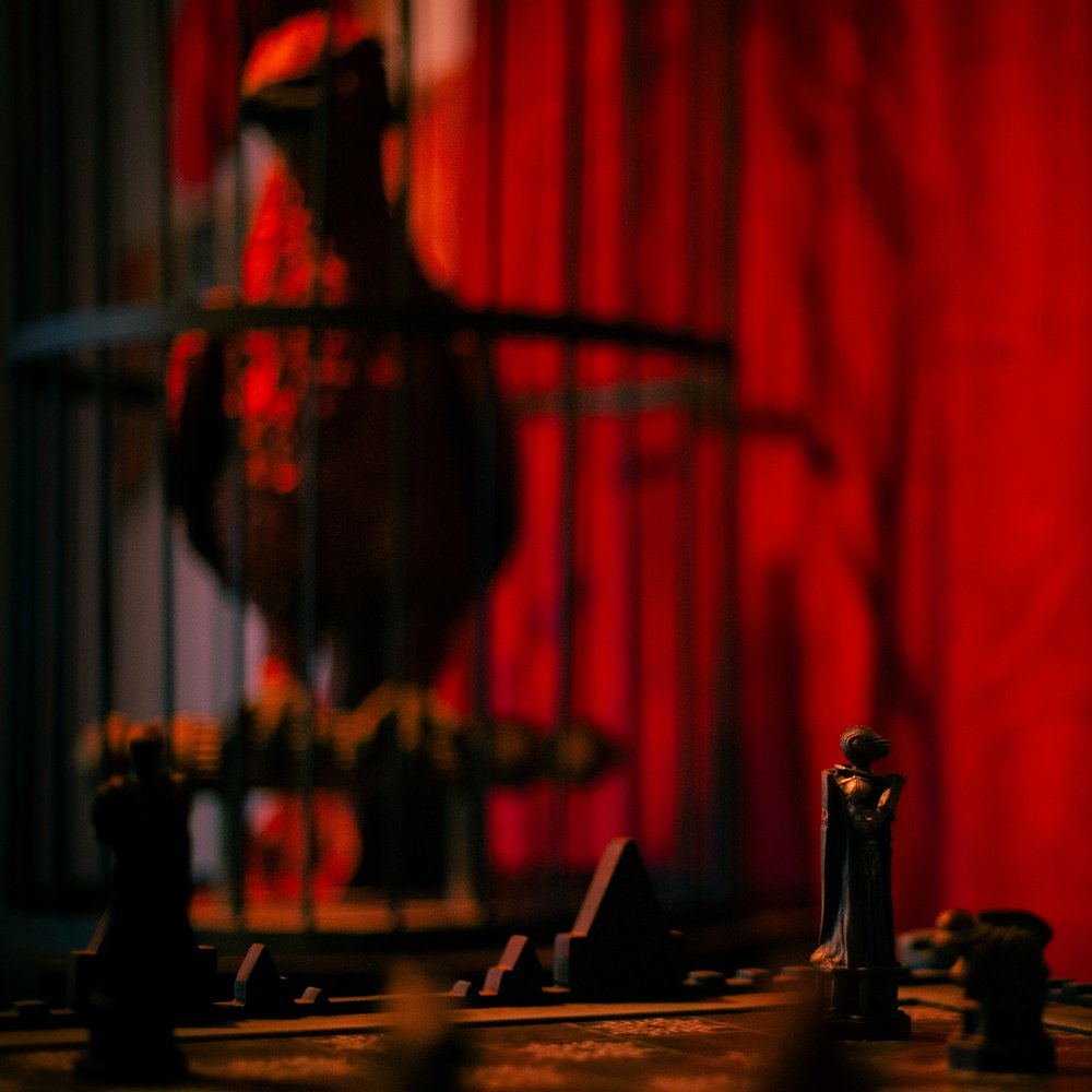 Magical chess pieces with a caged phoenix behind – Return of the Sorcerer puzzle room, Keyword Warsaw